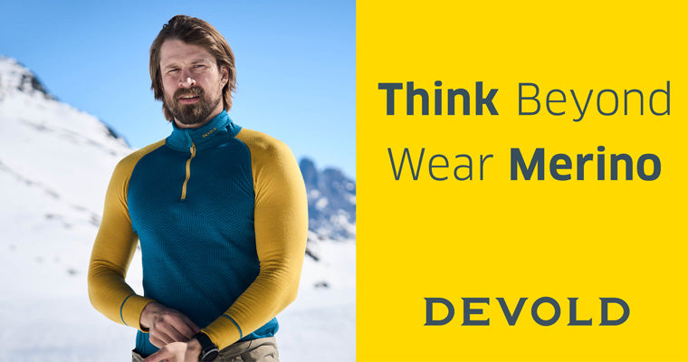 Auf dem Bild ist ein Mann zu sehen, der eine Longsleeve von DEVOLD in blau/gelb trägt.