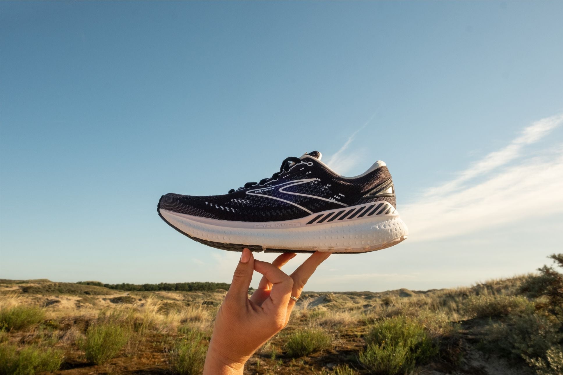 Ein Laufschuh von Brooks wird in die Höhe gehoben.