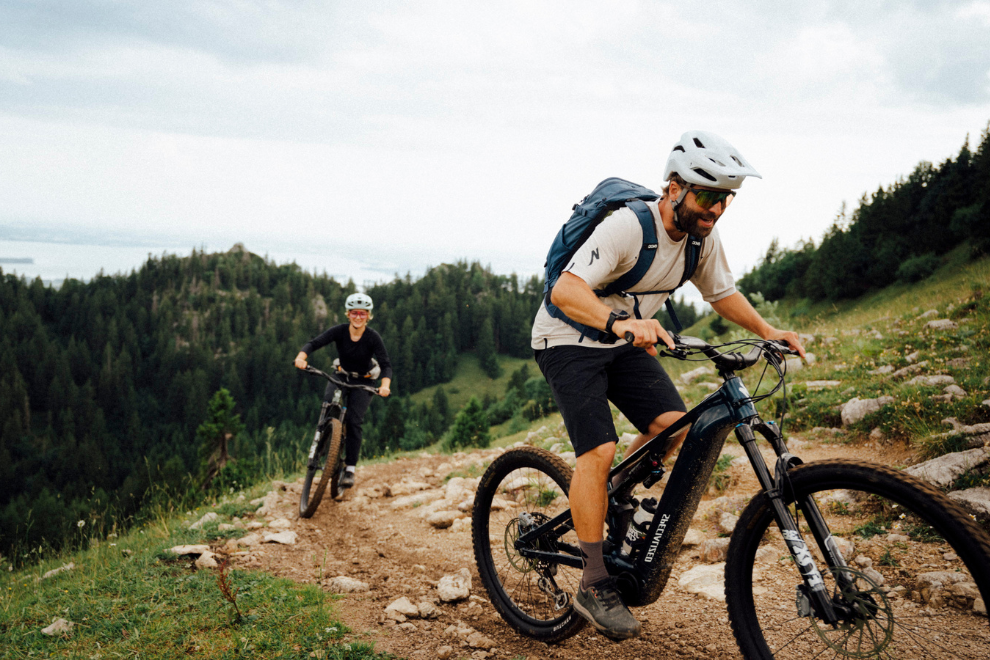 1 Mann und eine Frau fahren mit Specialized Fahrrädern einen Berg hoch.